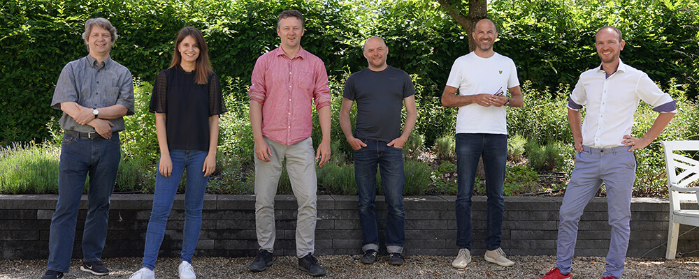 Das Team stellt sich vor. 6 Menschen stehen vor Grün
